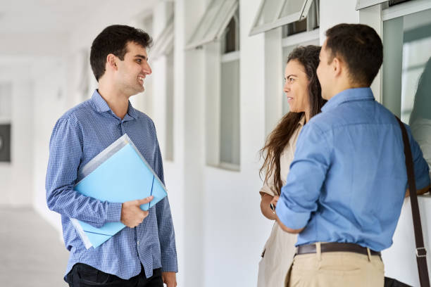 istock Group of three business associates discussing work in office corridor 1481428992