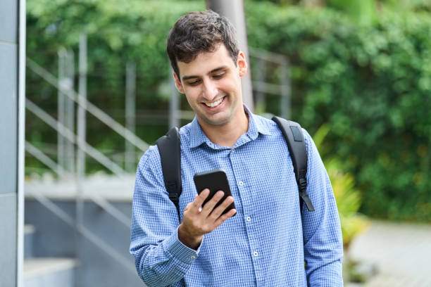 istock Young man using phone walking outside in city 1481429090