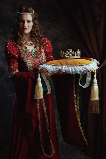 istock medieval queen in red dress with crown on pillow 1481430446