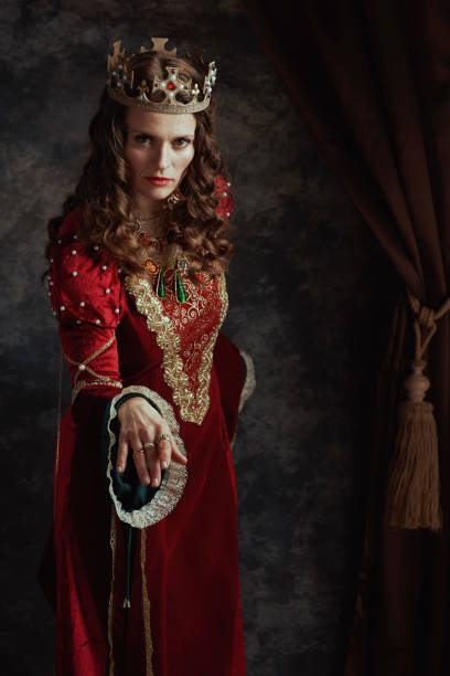 istock medieval queen in red dress with crown making reverence 1481430468