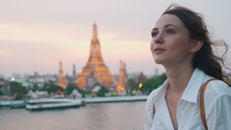 Woman looking at Wat Arun and Chao Phraya river