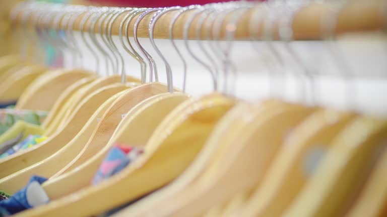 Multi colored clothes hanging on rack in store