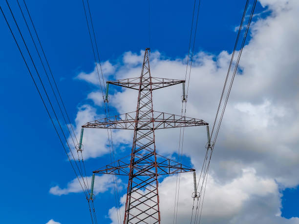 istock High voltage line poles and wires with blue sky and clouds background 1481434211