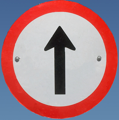 traffic sign wrong way arrow red with blue sky background