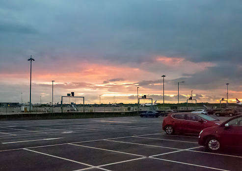 Cars parked at a UK airport at sunrise.