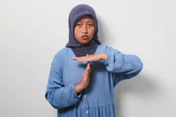 istock Serious young Asian girl in hijab doing time out gesture 1481438029