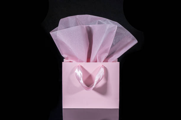 istock Craft paper gift bag with tissue paper isolated on a black background 1481438195