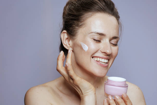 istock smiling young woman with cosmetic cream jar 1481439283