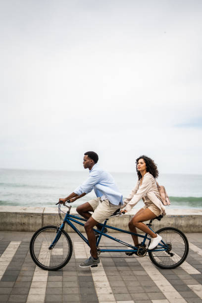 istock Young couple taking a ride on a double bicycle on coastline 1481444016