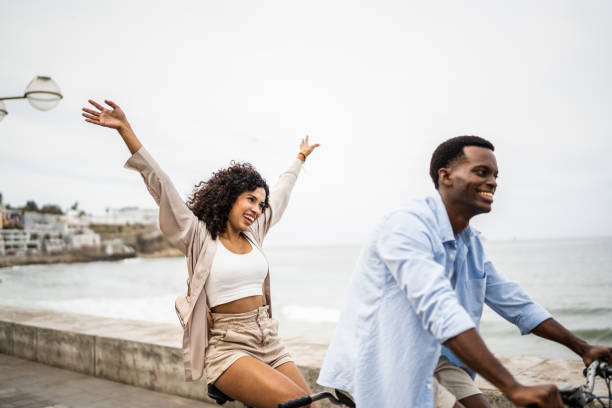 istock Young couple taking a ride on a double bicycle on a coastline 1481444020
