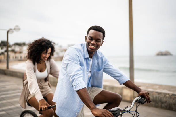 istock Young couple taking a ride on a double bicycle on coastline 1481444042