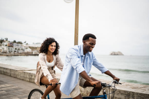 istock Young couple taking a ride on a double bicycle on coastline 1481444046