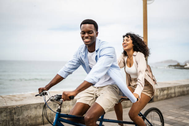 istock Young couple taking a ride on a double bicycle on coastline 1481444065