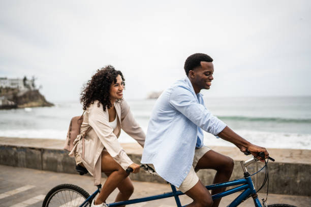 istock Young couple taking a ride on a double bicycle on coastline 1481444095