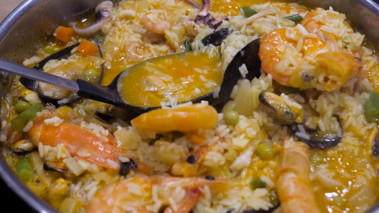 Hot Risotto With Seafood Cooking And Stirring With A Spoon