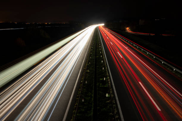 istock Red and white bright lights on the road. Night on the highway. 1481444210