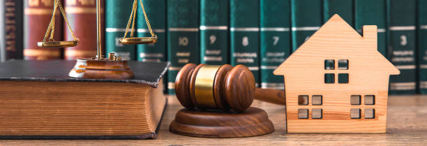istock Miniature House on wooden table and judge gavel. 1481444310