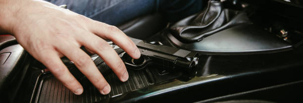 Man driving a car with gun stock photo