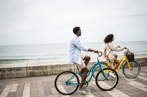 Young couple on a bicycle ride on the seacoast