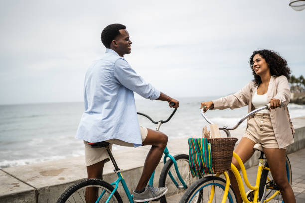 istock Young woman talking with boyfriend using a bicycle outdoors 1481444396