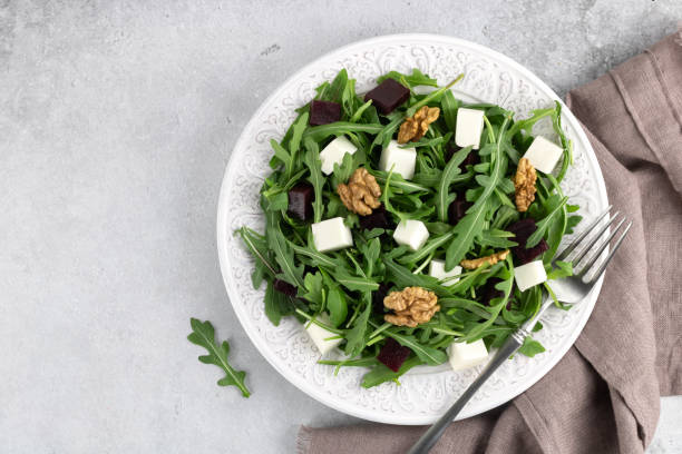 istock Beetroot salad with feta cheese, arugula and walnuts on a gray background. Top view. Copy space. 1481445567
