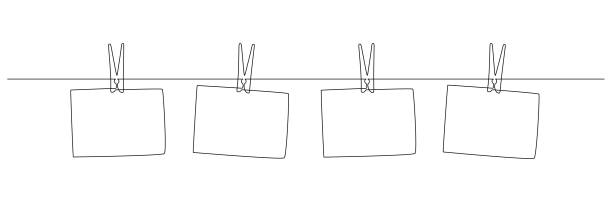 Photo frames hanging on the rope with clothespins in one continuous line drawing. Clothesline with pin and peg for photo album design concept in simple linear style. Editable stroke. Doodle vector Photo frames hanging on the rope with clothespins in one continuous line drawing. Clothesline with pin and peg for photo album design concept in simple linear style. Editable stroke. Doodle vector. photos hanging string stock illustrations