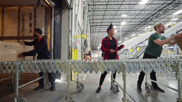 Young African American Man, Black Woman And Bearded White Man Moving Boxes Into Truck in Fulfillment Center
