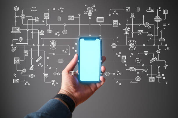 A hand of an influencer holding a mobile phone and connected  social media icons are coming out of from its shinny screen.