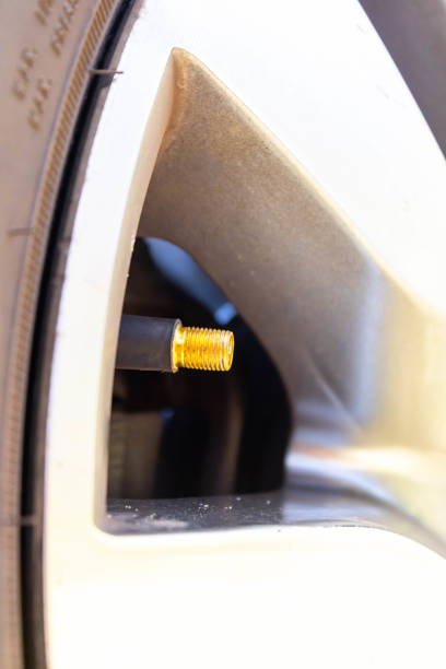 Ventil of a car tire without the cap in detail in yellow. I mention the care taken with car maintenance, concern with tire calibration before traveling with the family for a non-frustrated vacation. ventilación de un neumático de coche sin la tapa en detalle en amarillo. menciono el cuidado que se tiene con el mantenimiento del automóvil, la preocupación por la calibración de los neumáticos antes de viajar con la familia para unas vacaciones no