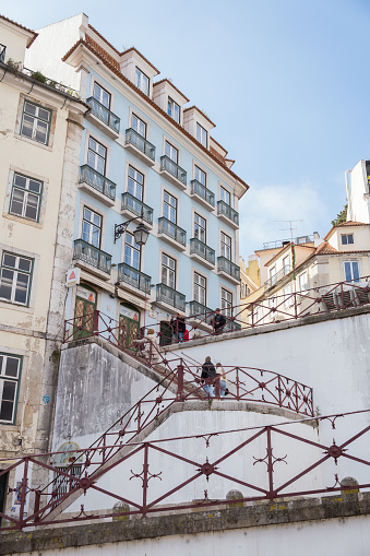 Lisbon, Portugal; February 26th 2023: Street with stairs leading to a building with a blue façade. Traditional streets and buildings in Lisbon (Portugal).