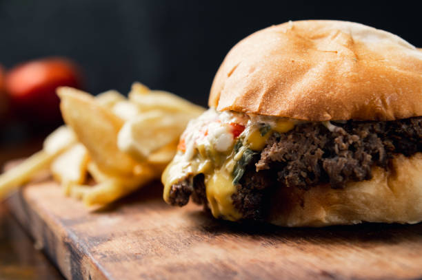 istock Delicious Cheeseburger with Crispy Fries and Fresh Vegetables on Potato Bread 1481452710