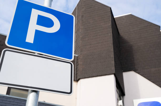 istock Car parking sign with copy space for text and a building in the background 1481454172