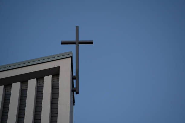 Cemetery chapel with a cross and blue evening sky in background