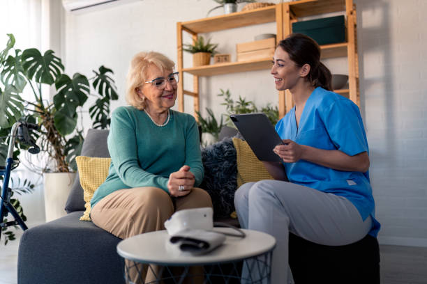 istock Smiling female home care worker taking notes on digital tablet during home visit 1481454685