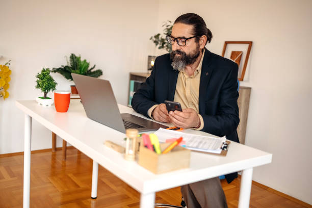 istock Businessman working in office with smartphone in his hands 1481464253