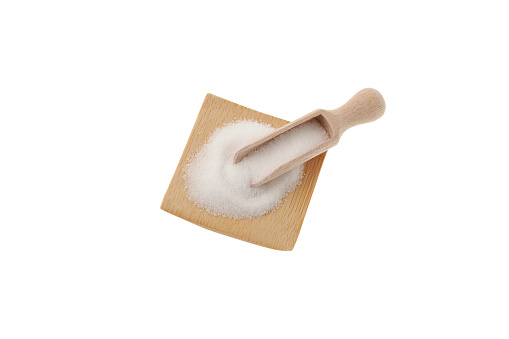 Xylitol powder or birch sugar in wooden scoop. Food additive E967, sweetener. Xylitol is used as sugar substitute in drugs, dietary supplements, confections, toothpaste, and chewing gum.