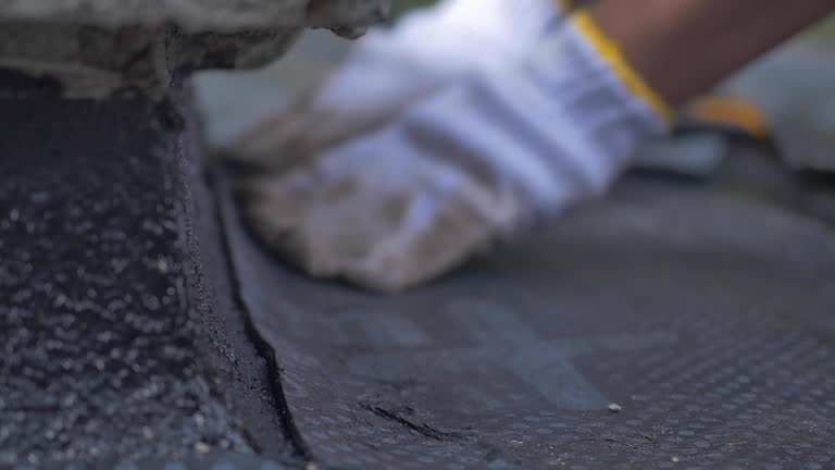 Construction worker sealing a waterproof layer on the roof