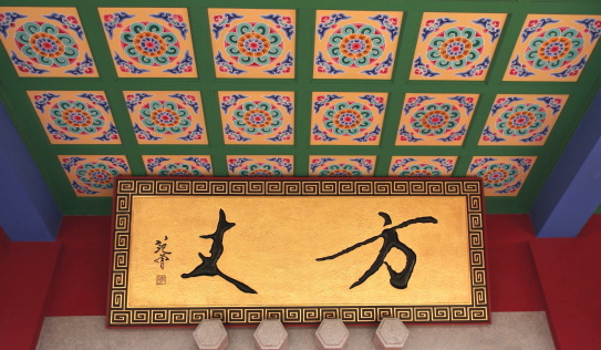Ceiling of a hall exhibiting schematic, abstract flowery decoration along with chinese pictograms and geometrical motifs, in the Huating-Pavilion of Splendour buddhist temple of the Xishan-Mountains of the West area rising over the Dian Chi-lake Dian, beside the town of Kunming, Yunnan, China.