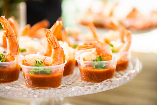 Individual Shrimp Cocktails Ready to Eat This is a close up photograph of individual shrimp cocktails ready to eat on a table outdoors during the day. shrimp cocktail stock pictures, royalty-free photos & images