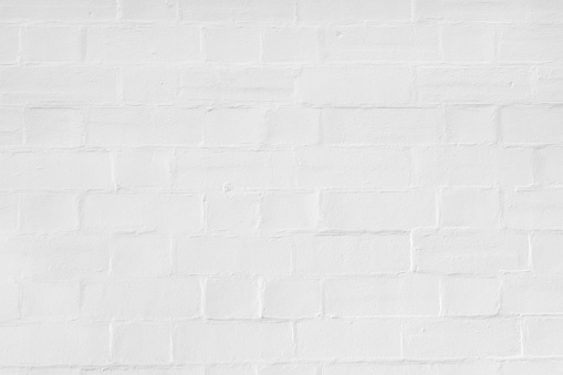 Closeup old brick wall painted white, abstract background with copy space, full frame horizontal composition