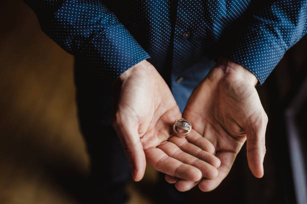 istock Groom holding wedding rings in his hands 1481482237