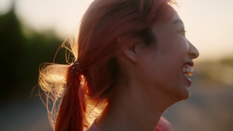 Woman sprinting and drinking water at sunset