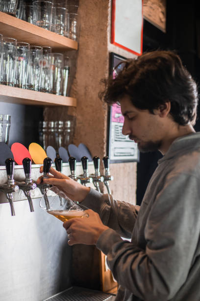 istock Young man is pouring beer in the beer pub. 1481489809