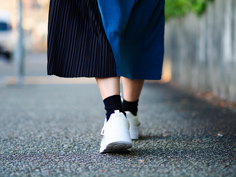 Woman walking in white sneakers