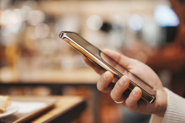 istock Woman's hand holding a smartphone and blurred background 1481497011
