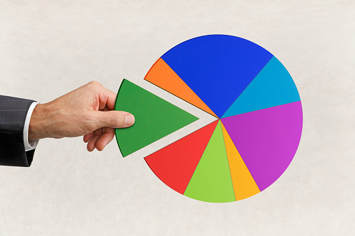 A man holds the missing piece of a pie chart.