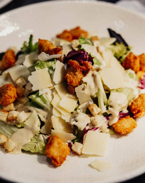 istock Caesar salad with croutons and cheese on a white plate 1481501943