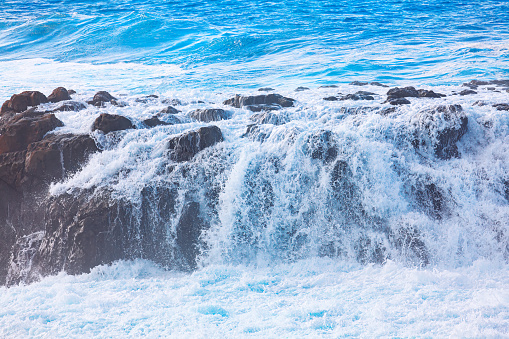 Ocean waves over rocks . Water cascade in the ocean