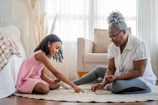 Grandmother and granddaughter playing dominoes