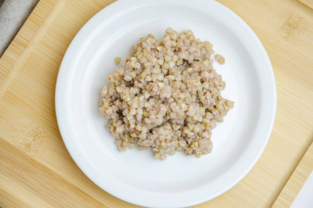 boiled green buckwheat on a white plate with a wooden spoon. High quality photo